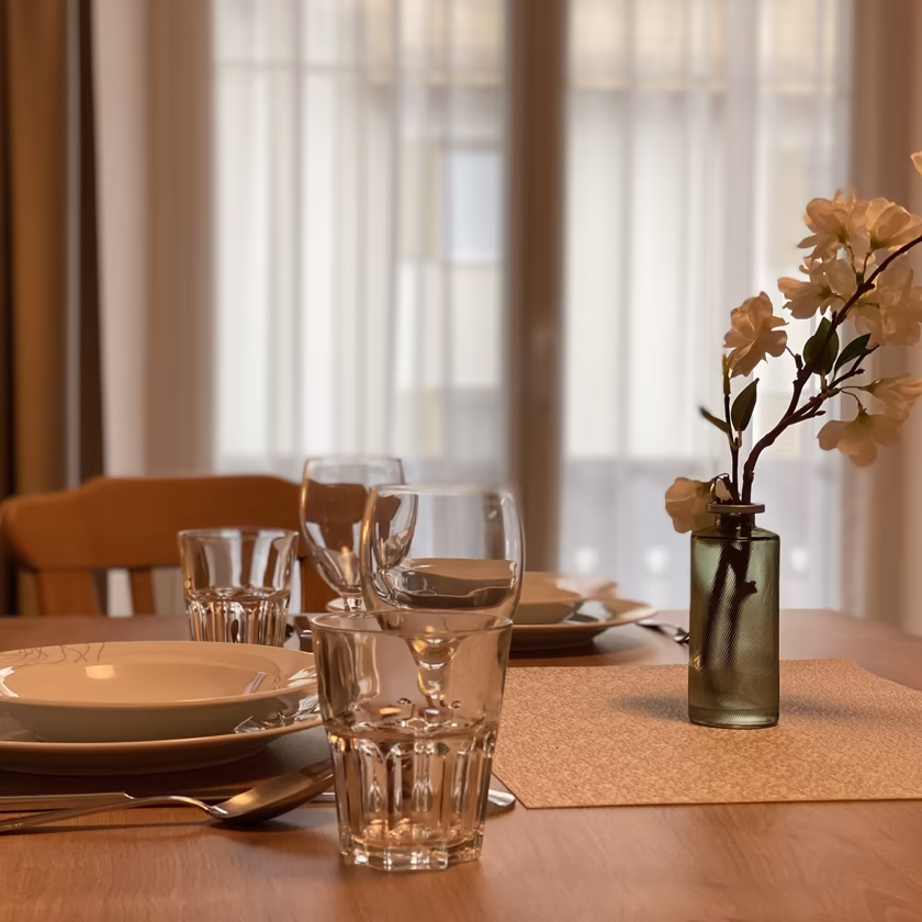 Gemütlicher Essbereich im Appartement 4 der Pension Eberharter in Mayrhofen mit gedecktem Tisch und Blumendekoration.